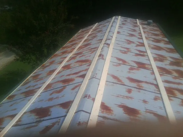 Rusted metal roof panels with new wood purlins before replacement — Storm Damage Roof Repair in Toston by Roofing Brothers